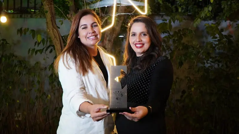 Renata Esteves, diretora de Gente e Gestão e Mônica Lima, coordenadora de T&D, recebem premiação Top 5 do Top of Mind RH, em nome do time BeFly. befly top mind