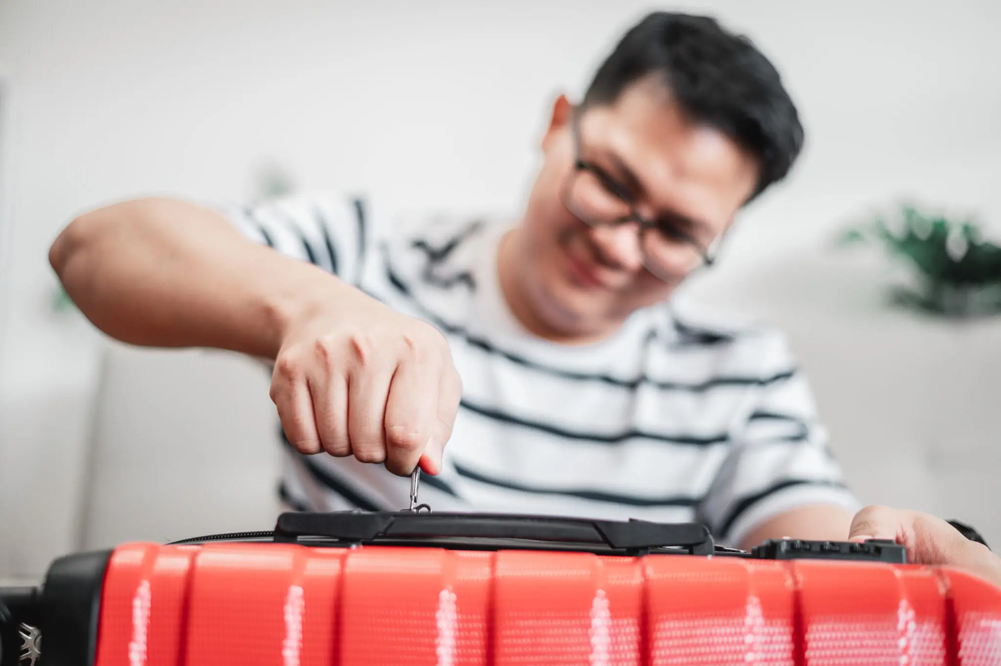 Close-up of man have finished packing and is locking them seguro viagem bagagens
