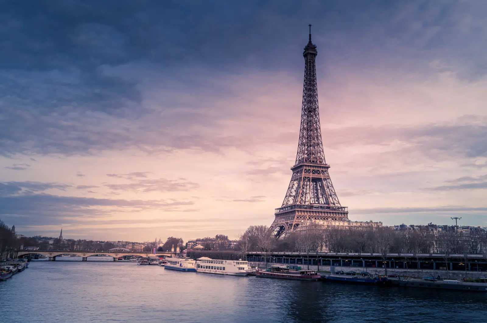 Freepick - beautiful-wide-shot-eiffel-tower-paris-surrounded-by-water-with-ships-colorful-sky bx Destinos internacionais, como Paris, se destacam (Foto: Freepik)