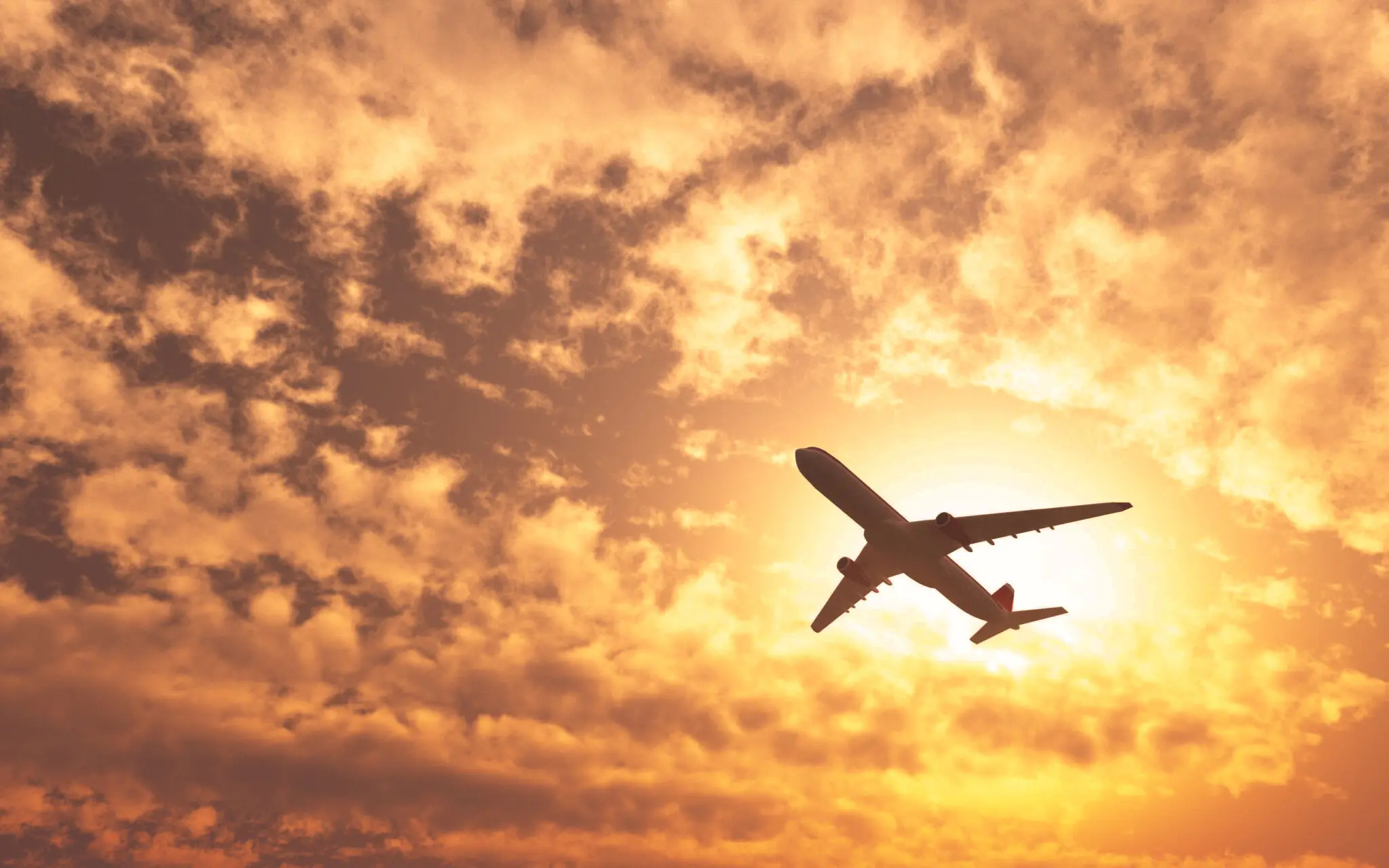 plane-passing-by-sun-cloudy-day