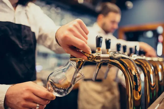 Two handsome bartenders poring beer at pub Setor eventos