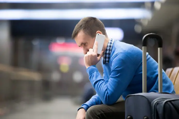 Young man on phone at airport aerolíneas argentinas