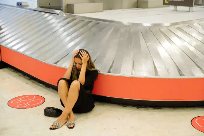 Frustrated woman lost baggage in airport bagagem seguro viagem