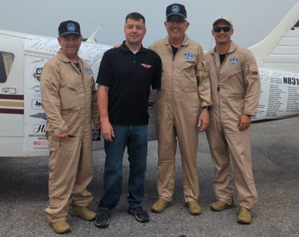 A tripulação com o veterano de guerra Adam Kisielewski, do Veterans Airlift Command, organização para a qual a missão arrecadou fundos durante a viagem
