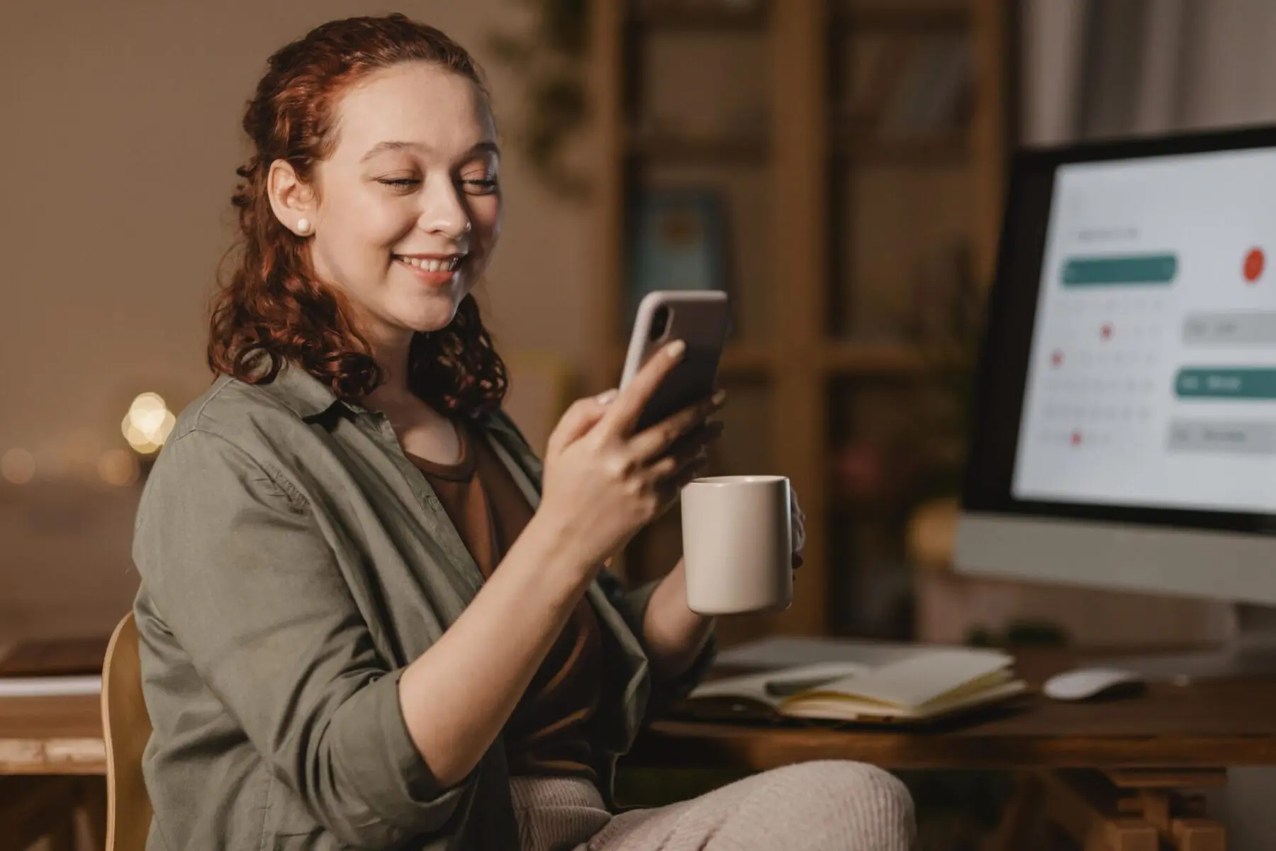 mulher-em-casa-usando-smartphone-na-frente-do-computador-enquanto-toma-cafe câmbio aplicativo