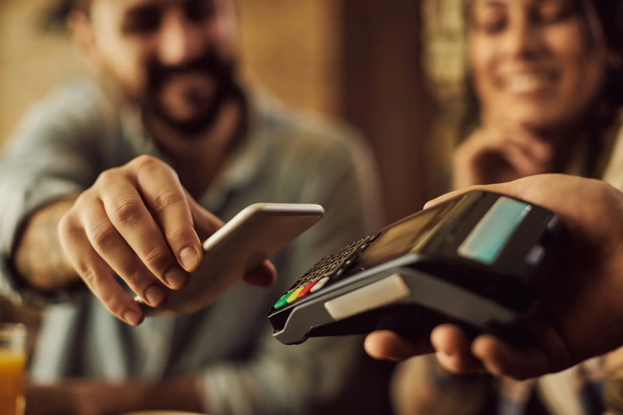 Close-up of man making contactless payment with smart phone. tax free reforma tributária