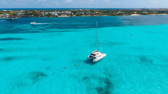 Aerial,Drone,View,Of,White,Catamaran,Sailboat,Anchored,On,Turquoise
